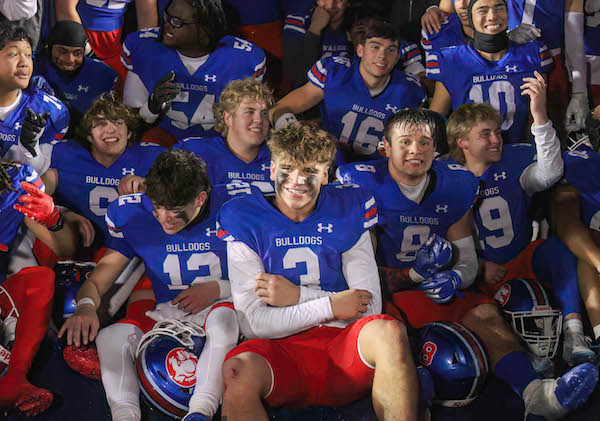 Ryder Lyons is centered and smiling amongst teammates as Folsom High celebrates a NorCal playoff win over Pittsburg.