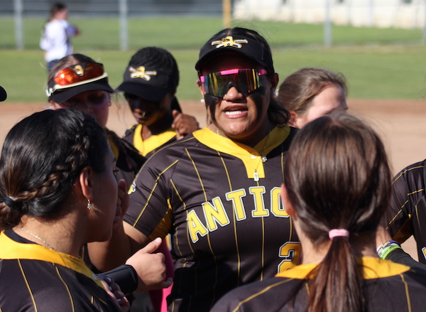 Antioch High junior softball player Fifita Grewe stands amidst her teammates as they huddle. 