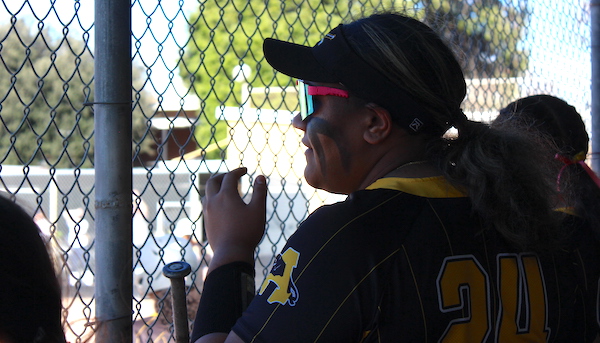 Antioch High junior softball player Fifita Grewe watches play unfold from behind the dugout fence. 
